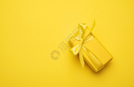 黄纸包着礼品的黄色矩形盒体背景图片