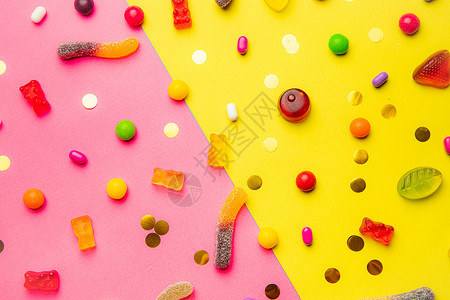 糖果什锦布局 在黄粉色背景上布置糖果 有嚼劲的果酱和小焦糖 明亮的背景 适合各种口味的糖果 关于糖果的文章 童年 鲜艳的色彩背景图片