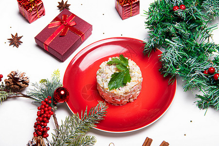 盘子里的礼物红色盘子里的奥利维尔沙拉 奥利维尔圣诞节 与沙拉的圣诞节布局 新年 假期 喜庆的菜 餐桌装饰 资本沙拉 蛋黄酱背景