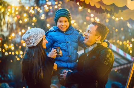 德国圣诞市场家庭在圣诞节市场上玩得开心背景