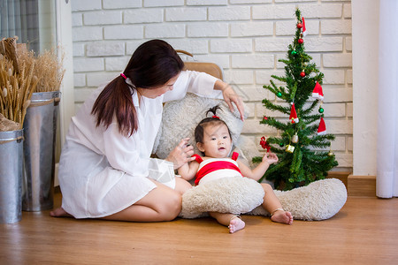 穿着圣诞装饰的可爱女婴全长穿着圣诞服装盛装满天花 新生 传统背景图片