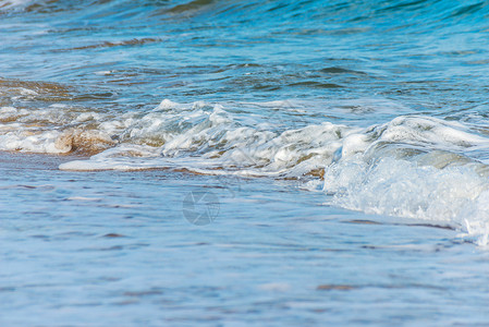 海水的特写影响沙滩上的沙子 海浪平静地流沙 放松的景色 阳光 支撑背景图片