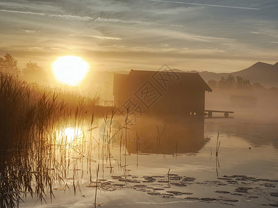 在Kochelsee湖对船屋的浪漫日出反射高清图片
