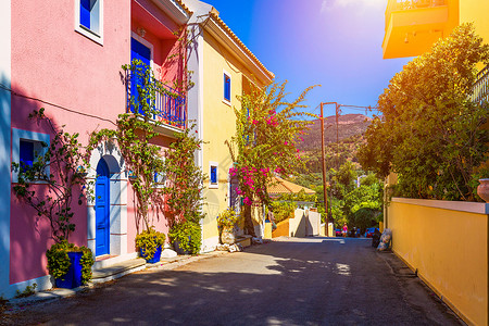 凯法利尼亚岛阿索斯的传统街道上有带鲜花的希腊房屋 Assos 村的传统色彩缤纷的希腊房屋 盛开的紫红色植物花 凯法利尼亚岛 希腊背景图片