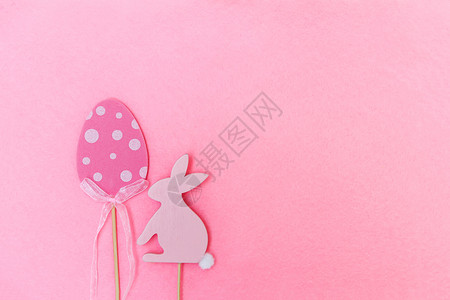 兔子形状棒棒糖由传统装饰品构成的复活节 木质装饰鸡蛋和兔子用软光粉红色背景呈现的数字 宗教 天背景