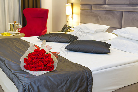 在酒店蜜月房间的床上 盛放红玫瑰 在酒店举行浪漫的客人会议 笑声 美丽的 幸福背景图片