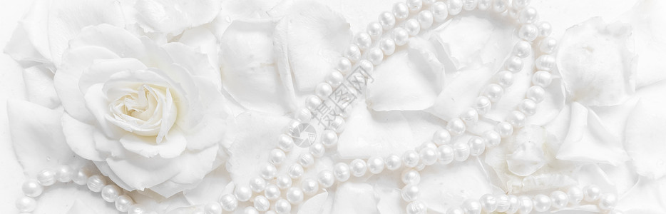 母亲节珠宝广告语美丽的白玫瑰和珍珠项链 放在花瓣背景上 为婚礼 生日 情人节 母亲节的贺卡提供理想 庆典背景