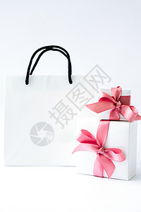 包样机空白纸白色袋子和两个礼品盒 白色背景上有粉色丝带 黑色星期五销售 购物概念 纸质购物袋样机 消费主义 展示背景