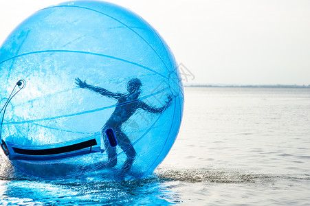 滚球一个女孩在充气的吸引力中 以海面球的形式出现 透明的 假期背景