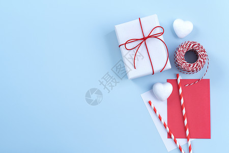 情人节母亲节艺术设计理念-红白包装礼盒隔离在柔和的浅蓝色背景平顶视图 礼物 蝴蝶结背景图片