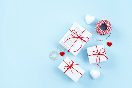 情人节母亲节艺术设计理念-红白包装礼盒隔离在柔和的浅蓝色背景平顶视图 信封 心背景图片
