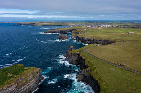 cliff爱尔兰著名的旅游里程碑莫赫克里夫 Moher Cliff 的美丽绿色山峰空中景象 海浪白天在云层下撞击岩石背景