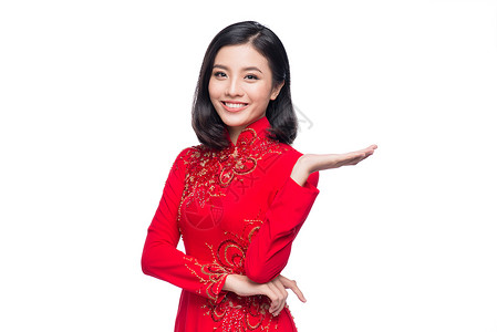 穿着传统Ao Dai服装的笑脸越南妇女 并介绍白背景 快乐的 红色的背景图片