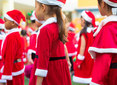 在小学圣诞派对上穿红主题服装的女生在小学里 美丽的 红色的背景图片