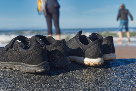 沙滩岩石上两双鞋子的地平面视图背景图片