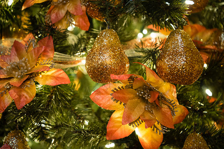 圣诞树装饰品 金色闪光和橙色花朵 关闭你 十二月 金子背景图片