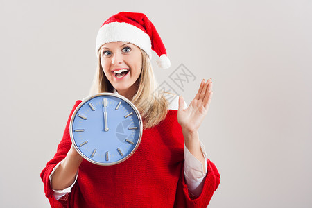 快乐的女士与圣诞老人帽子 握着时钟背景图片