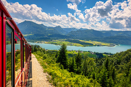 庞沙冈登山火车 Schafberg 山 萨尔茨卡默古特地区 萨尔茨堡州 奥地利 穿越郁郁葱葱的田野和绿色森林前往阿尔卑斯山顶 沃尔夫冈背景