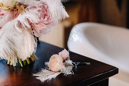 新娘的婚礼花束玫瑰 装饰着白羽毛和胸衣 新娘捧花背景图片