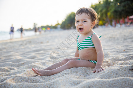 在沙滩上疲累的小孩打哈欠图片