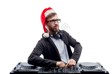 戴着圣诞老人帽子的有趣的Dj家伙 眼镜在转盘上演奏音乐 而以白色背景与世隔绝背景图片