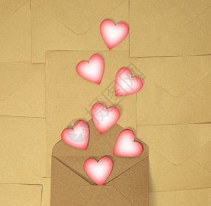 纸制工艺信封 棕色纯色背景上有粉红色的心 爱的概念和情人节 Daytop 视图复制 spac背景图片