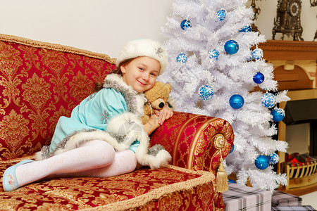 穿着雪雪少女服装的小女孩 还有一只泰迪熊 假期 圣诞节背景图片
