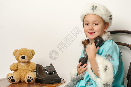 一个穿雪雪少女服装的小女孩 正在谈论旧Pho 童年 假期背景图片