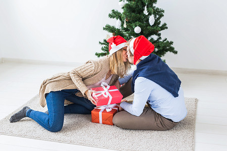 假日概念   开圣诞礼物的情侣 坐在客厅里 微笑 男人背景图片