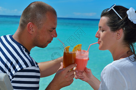快乐的年轻情侣放松 喝杯新鲜饮料 海背景图片