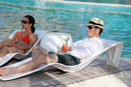 快乐的年轻情侣放松 喝杯新鲜饮料 海 太阳背景图片