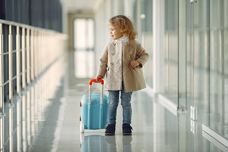 在机场拿着手提箱的小女孩儿 假期 室内的 到达背景图片
