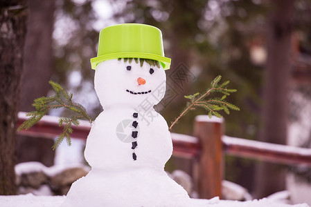 绿色帽子的雪人带着绿色帽子微笑的雪人 冬天 降雪 寒冷 好玩的 场景背景