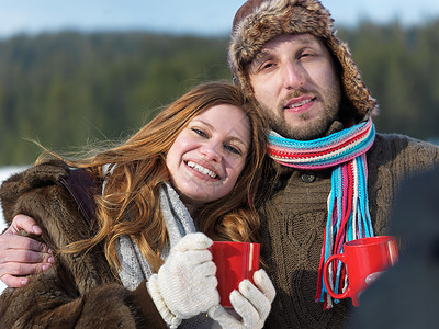 快乐的年轻夫妇在冬天喝热茶 时尚 男人 红发图片