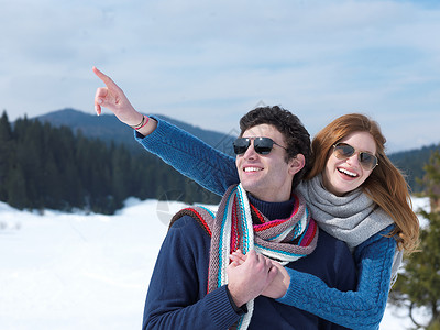 快乐的年轻情侣在冬季假期 新秀上玩得开心 家庭 滑雪背景