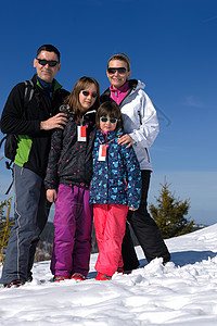 冬季快乐的年轻家庭肖像 户外 太阳 天空 假期 高山背景图片