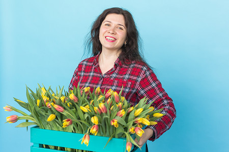 欢乐的女性花卉女花店员笑着 天 礼物 美丽的 蓝色的背景图片