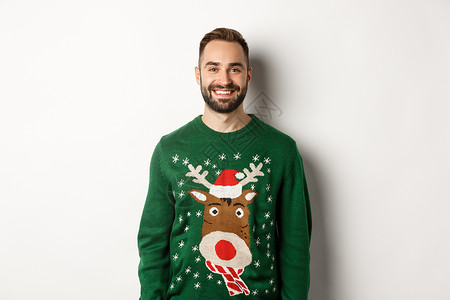 新年晚会和冬季假日概念 快乐的长胡子男子穿着有趣的圣诞节毛衣 站在白色背景下站立 成人 购物背景图片