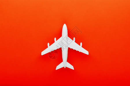 白色客机模型飞机在明亮红色背景上 空闲文本空间 旅游 干净的背景
