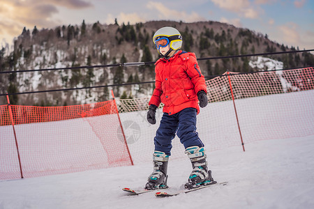 儿童在山中滑雪 带安全帽 护目镜和杆的活跃蹒跚学步的孩子 幼儿滑雪比赛 家庭的冬季运动 高山学校的孩子们滑雪课 小滑雪者在雪地里背景