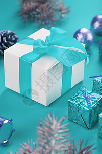 蓝色上的白箱圣诞礼物以白箱形式出现 蓝弓在蓝色背景上 围绕圣诞节的装饰品背景