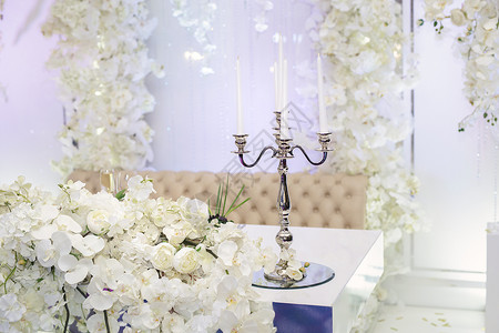 在婚礼宴席上用鲜花装饰的蜡烛挂着 花束 庆祝背景图片