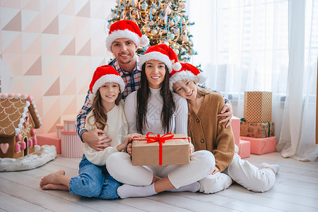 快乐的年轻家庭 有孩子拿着圣诞礼物 圣诞老人 女孩们背景图片