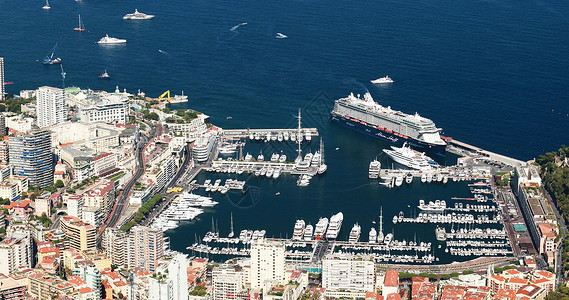 天线许多的在阳光明媚的日落时 摩纳哥公国大港赫库勒 Monte-Carlo 的空中景象 La Turbie Megayachts 许多船只背景