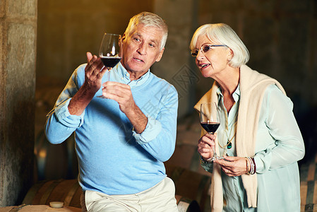 这是完美的葡萄酒杯 一对年长的情侣 享受了一点点葡萄酒品尝图片