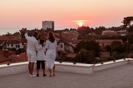 屋顶时光图片幸福的家庭在屋顶上享受和共度时光 同时一起在公海观看日落 健康 水背景