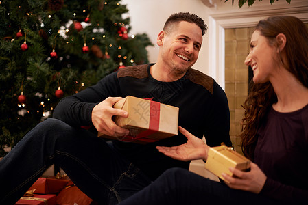树上最好的礼物是爱 一个快乐的年轻夫妇 在圣诞节开业礼物 笑声背景