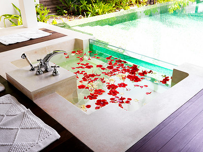 现代洗手间在温泉度假胜地装满鲜花花瓣浴缸背景图片
