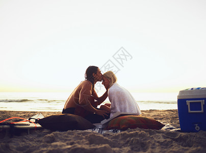 41愚你分享你不只是给任何人额头的吻 拍摄一对年轻恩爱的情侣在日落时分在海滩上约会时分享温柔的时刻背景