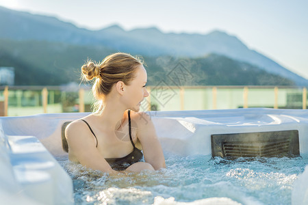 热水浴缸性质在绿色大山的背景下享受快乐旅行时刻假期生活的年轻无忧无虑的快乐微笑女人在热水浴缸中放松的肖像 快乐的 温泉背景